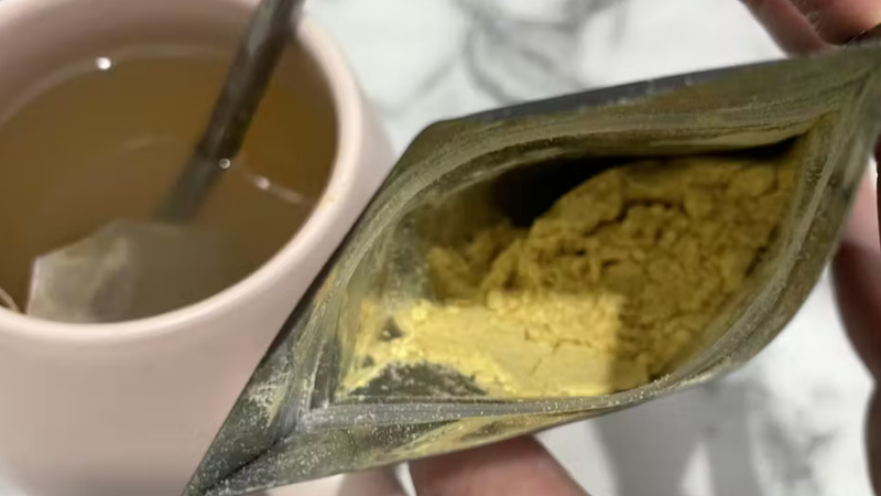 Lion’s Mane extract powder sachet opened beside a warm tea, showing fine powder texture and suitability for drink mixes.