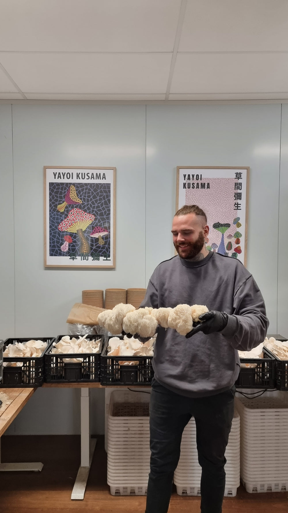 Xotic grower holding a large Lion’s Mane harvest in the packing room